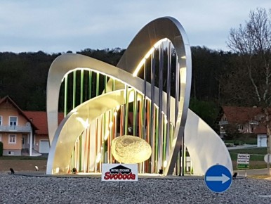 Kreisverkehrskulptur Gemeinde Sebersdorf/Bad Waltersdorf abends beleuchtet | Alubögen mit bunten Stangen & Stein | Svoboda