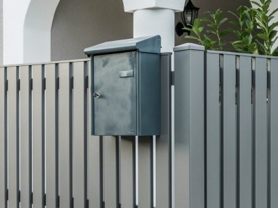 ZA Baden 13 a | auf vertikale Zaunlatten aufgehängter Metall-Postkasten grau beschichtet | Svoboda