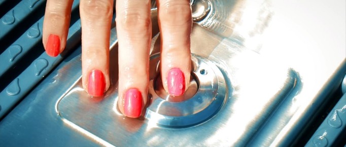 Frauenhand beim Aktivieren des Knopfes für Lufsprudel-Anlage bei Niropool | Svoboda Edelstahlpools