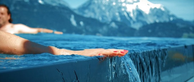 Frauenhand beim Entlangfahren an Edelstahl-Überlauf-Kante bei Infinity-Pool | Svoboda Edelstahlpools