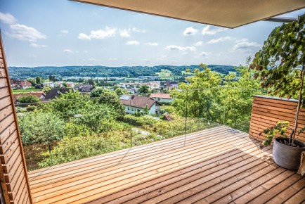 Augsburg 20 l | Ganzglas-Geländer modern bei Balkon mit Holzverkleidung, Aussicht auf Dorf | Svoboda