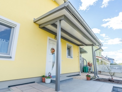 Vordach Alu 43 a | Graues Aludach bei Eingangstür mit weißer Paneeleindeckung, gelbes Haus | Svoboda