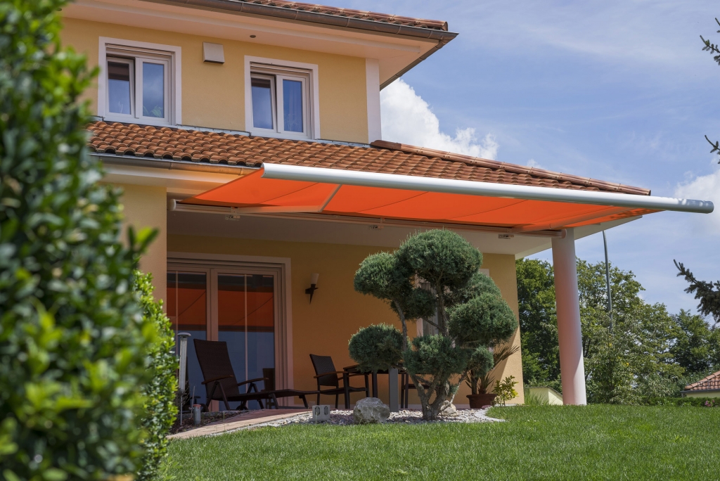 C 07 | Orange Kassettenmarkise auf Terrasse bei Haus im spanischen Stil | Svoboda Metalltechnik