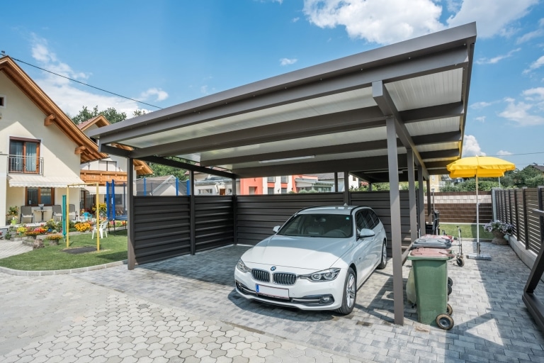 Carport 19 a | braunes Doppelcarport mit weißer Paneeleindeckung und seitlichem Sichtschutz, weißer BMW | Svoboda Metalltechnik