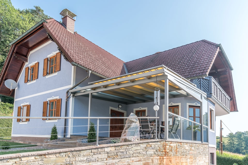 TM 06 e | gelbe Sonnenschutzmarkise auf Alu-Dach bei blauem Haus auf Terrasse | Svoboda