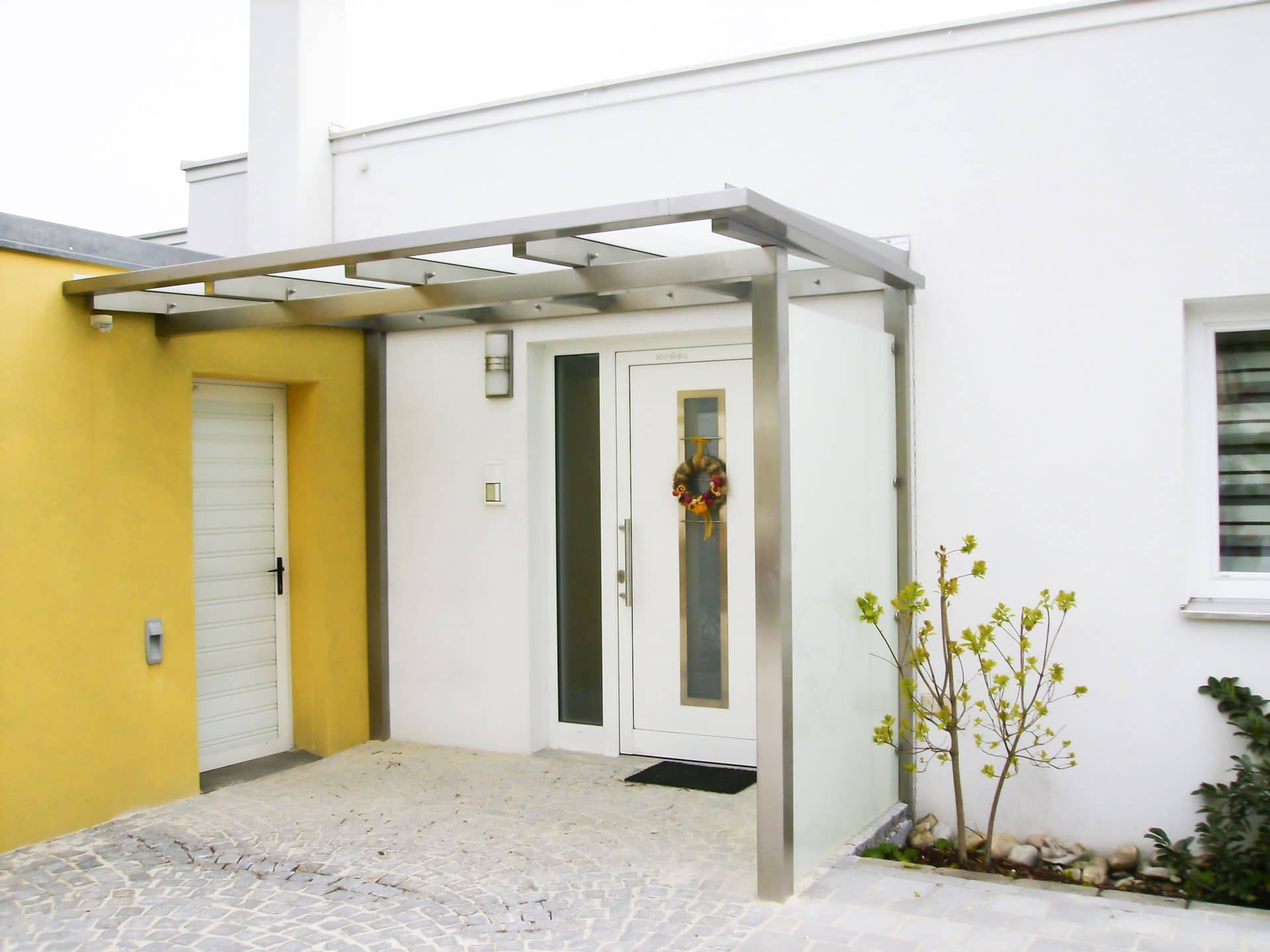 Vordach Niro 11 | Eingangsüberdachung mit seitlichem Windschutz aus Mattglas | Svoboda Metalltechnik