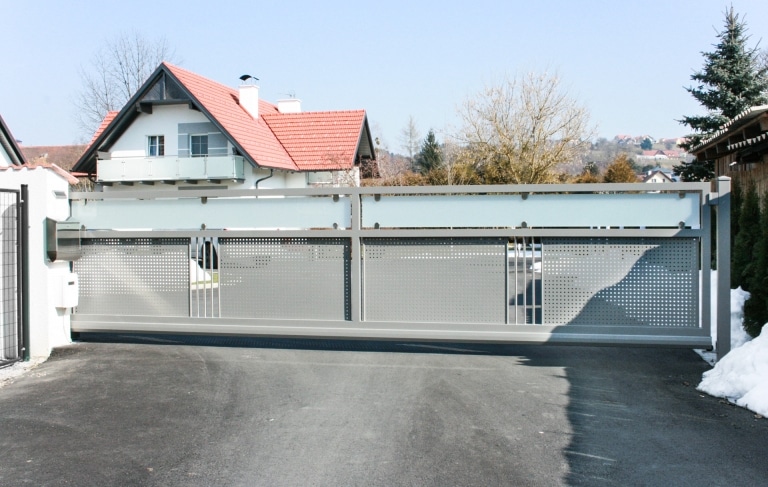 ZA Güssing 15 a | elektrisches Aluminium-Einfahrtstor hellgrau mit Lochblech und Mattglas | Svoboda