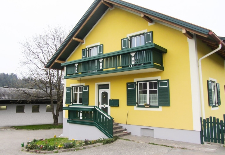Kapfenberg 22 | grün-weißer Alubalkon und Stiegengeländer bei gelbem Haus mit Spitzdach | Svoboda