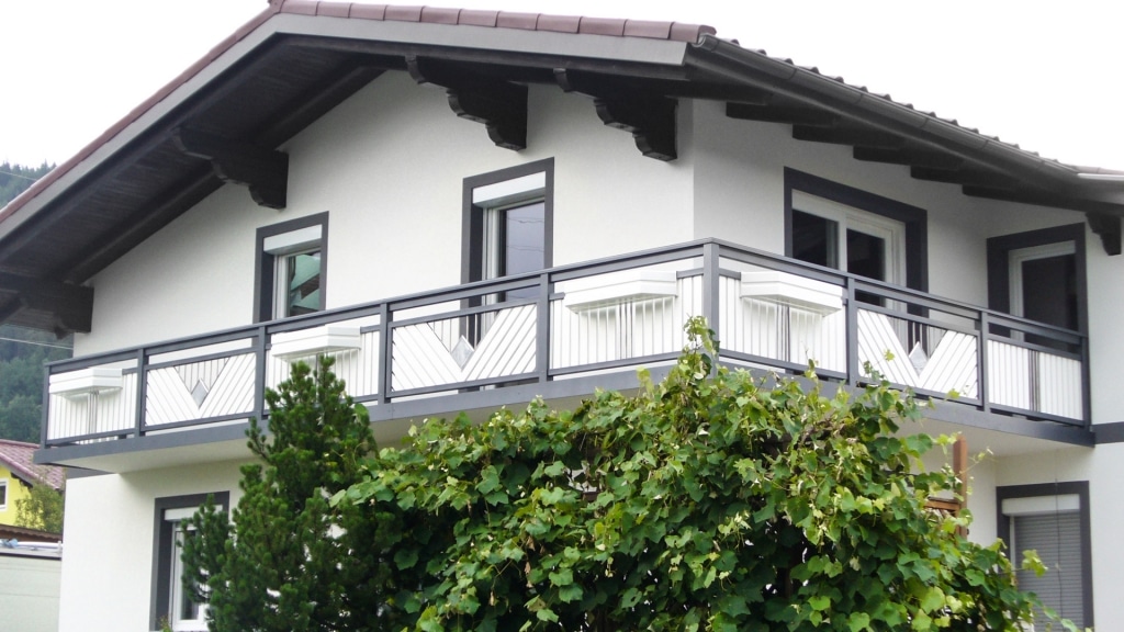 Saalfelden 04 a | grau-weißer Balkon mit Edelstahl Dreieck mit Stäben und Stein gefüllt | Svoboda