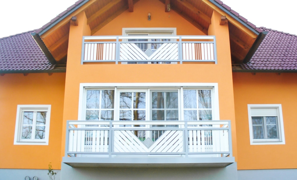 Saalfelden 05 | Aluminium-Geländer grau weiß mit Stein und Edelstahl bei orangem Haus | Svoboda
