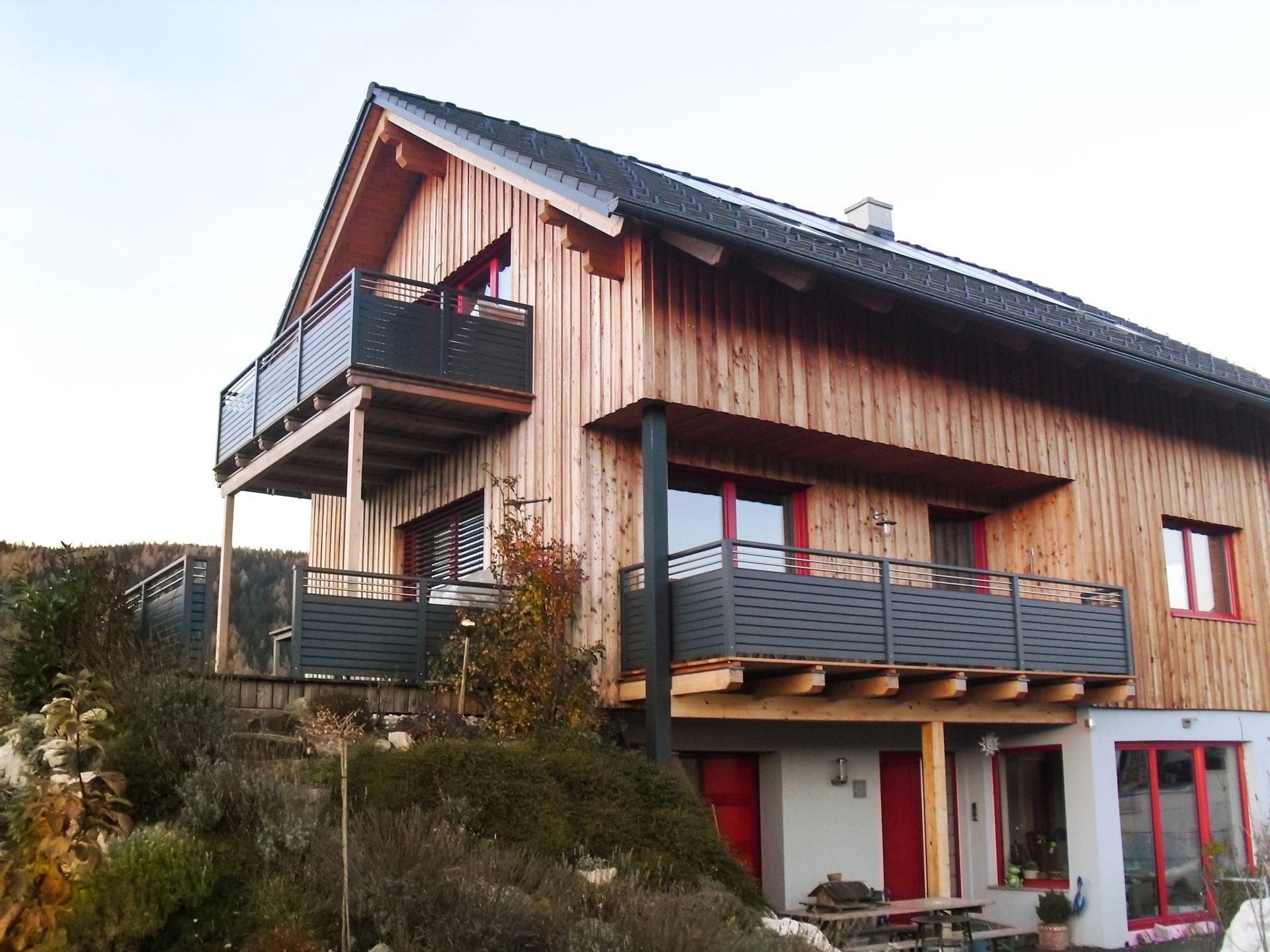 Telfs 06 | Moderner Alubalkon mit Querlattung grau und Nirostäben bei Haus mit Holzfassade | Svoboda