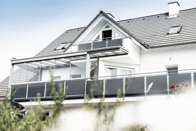 Bremen 80 g | Modernes Grauglas Edelstahl-Geländer bei weißem Haus mit grauem Dach | Svoboda