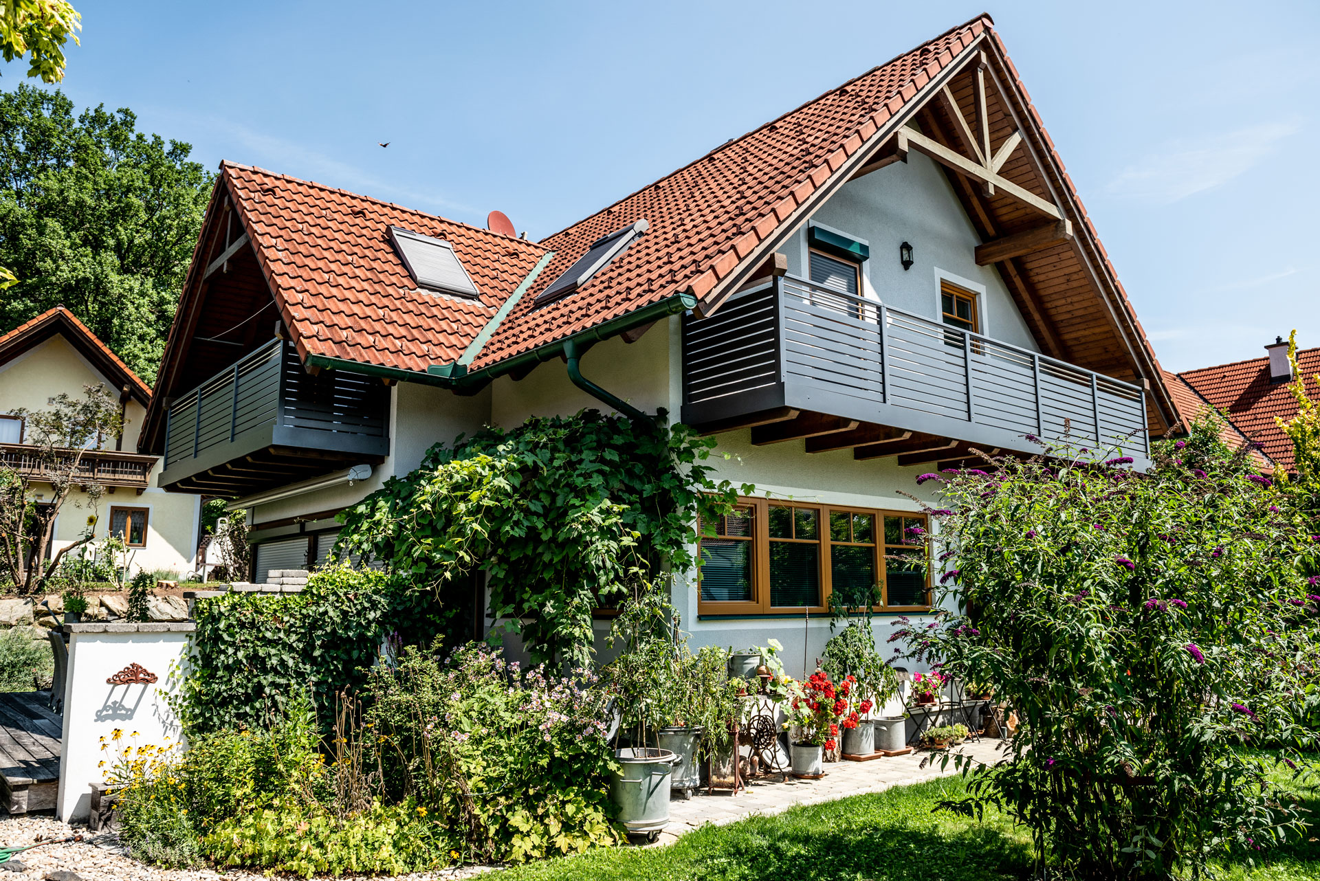 Telfs 17 a | Haus mit rotem Ziegel-Satteldach und modernem querlatten Alu-Balkongeländer | Svoboda